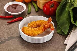 A bowl of fried shrimp with a side of sauce photo