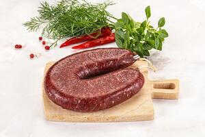 A piece of meat on a cutting board with herbs photo