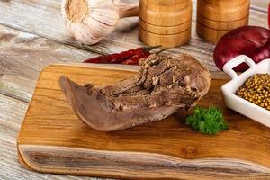 A piece of meat on a cutting board with spices photo