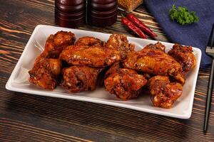 A plate of chicken wings on a table photo