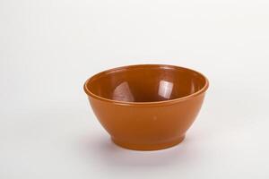 A small brown bowl on a white surface photo