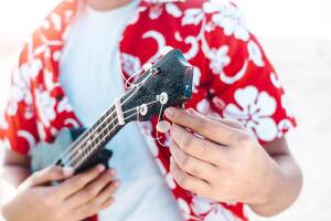hands of a person holding and tuning a string instrument or ukulele. music concept. photo
