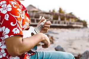 unrecognizable person holding a playing chords with an instrument string called a guitar or ukulele. concept. photo