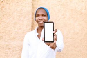 handsome man looking at camera holding with hands a mobile phone with a white screen. photo