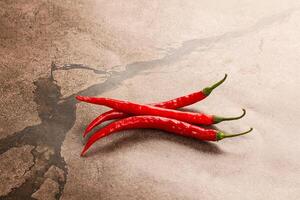 Three red chili peppers on a table photo