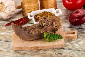 A piece of meat on a cutting board with spices photo