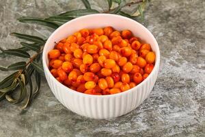 A bowl of orange berries on a table photo