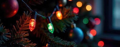 Glowing light bulbs in a garland on a dark Christmas tree add a pop of color, festive lights, colorful, ornaments photo