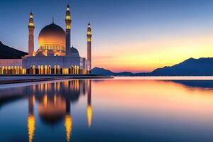 Mosque reflecting on water surface at sunset with mountain range in background photo