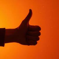 A person's hand is shown with a thumbs up photo