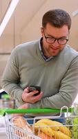 Man checking grocery list on phone while shopping video