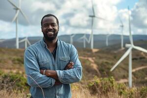 Smiling Black man standing confidently in front of wind turbines, showcasing a commitment to renewable energy. photo