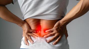 A man experiencing lower back pain, highlighting discomfort with a pained expression. photo