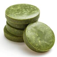 Four stacked green soap bars made from natural ingredients, showcasing a unique texture and rich color. photo