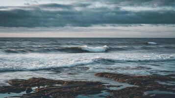 A view of the ocean with waves crashing on rocks photo