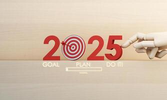 A bold red 2025 stands on a wooden surface, symbolizing determination. A dart hits the target, and a robotic hand interacts with the number, representing progress toward goals. 3d rendering. photo
