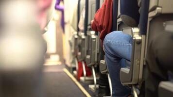 The passengers are sitting in their seats. An airplane cabin with rows of seats along the aisle. Morning light in the cabin of an airline plane. Economy class video