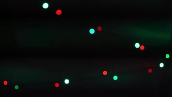 Christmas colorful garlands on a dark multicolored background are flashing in different colors. video
