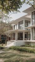 A modern home with large windows and a large lawn photo