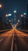 A long empty highway with city lights in the background photo