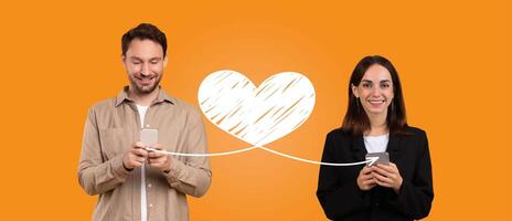 A couple stands together, smiling while using their smartphones to send affectionate messages on St. Valentines Day. Orange background highlights their loving connection. photo