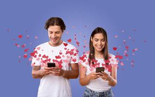 A happy couple stands side by side, each using their smartphone to send affectionate messages online. Surrounded by floating hearts, they embody love and connection on Valentine's Day. photo