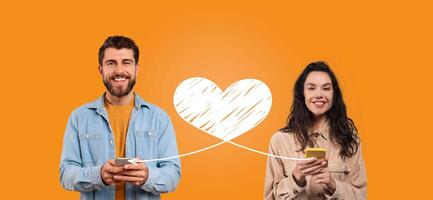 A couple joyfully connects on Valentine's Day, sending affectionate messages using their smartphones. They share a happy moment isolated against a bright orange background. photo