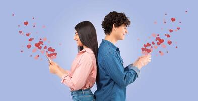 A couple enjoys a romantic Valentine's Day, sitting back to back while using their smartphones. photo