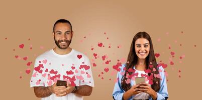 A couple enjoys a virtual connection on St. Valentine's Day, sharing love through their smartphones. Surrounded by colorful hearts, they express affection while celebrating together. photo