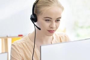 Young tech support operators at work in contemporary call centre. Millennial hotline agents using computers at office, consulting clients, selling goods on phone. Telecommunications concept photo