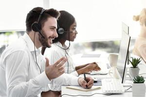 Team of customer service representatives assisting clients, resolving technical issues or selling products at modern call centre. Group of hotline operators working in telemarketing photo