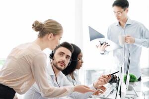 Team of call centre operators at work in open space office photo