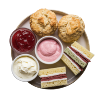 Overhead view of a dessert plate featuring scones, sandwiches, jam, cream, and strawberry spread isolated on transparent background png