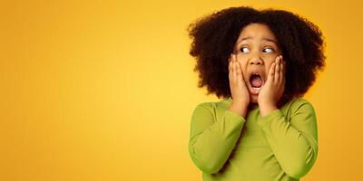 Omg. Portrait Of Shocked Little Girl Touching Her Face In Amazement And Looking Aside At Copy Space On Yellow Background, photo