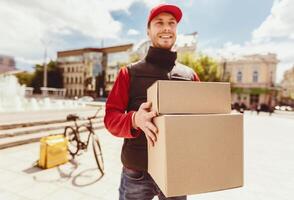Delivery Service. Courier Man Delivering Boxes, Parcels And Food In City. Selective Focus, Free Space photo