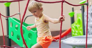 Child playing on colorful playground ropes video