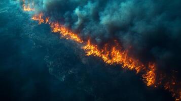 A large wildfire engulfs the terrain, flames raging along the ground while thick smoke rises ominously. The event showcases the intensity of natural disasters and their impact on the environment. photo