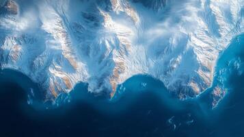 An expansive, satellite view captures a rugged coastline bordered by snowy mountains and deep blue waters, ideal for telemetry and surveillance analysis. photo