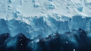 This aerial view captures the edge of an ice shelf in a polar region, highlighting the interactions between ice and ocean water. Geospatial analysis is crucial for understanding environmental changes. photo