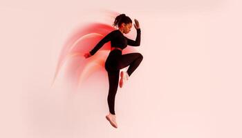 Dynamic moves. Determined African American lady exercising, doing elbow to knee crunches or jumping on red neon studio background, full length, side view photo