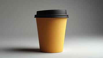 A vibrant yellow coffee cup with a black lid stands alone against a soft gray background. The focus emphasizes its simple yet striking design, ideal for a cozy beverage. photo