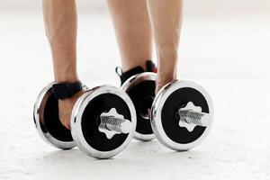 Health and strength training. Woman with fitness tracker doing hand bends and exercises with dumbbells at home during quarantine, cropped, copy space photo