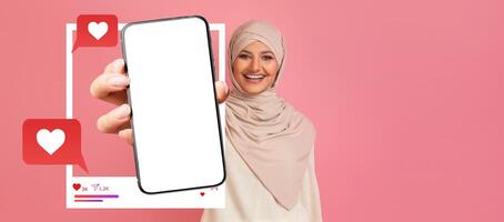 An influencer smiles while holding a smartphone with a blank screen, ready for social media engagement. Chat bubbles and heart icons enhance the digital atmosphere of connection. photo