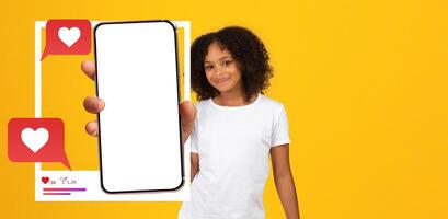 A young influencer poses with a smartphone in hand, displaying a blank screen. The vibrant yellow background enhances the lively mood, emphasizing connection and interaction online. photo