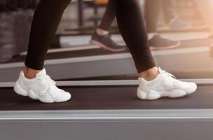 A person walks steadily on a treadmill in a modern gym, focusing on their workout. The atmosphere is energetic and designed for fitness enthusiasts. photo
