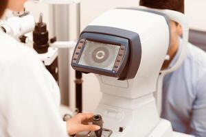 A patient undergoes an eye examination while a medical professional operates diagnostic equipment to assess vision health and detect any issues present in the patient's eyes. photo