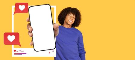 An influencer smiles while holding a blank smartphone screen, inviting interaction on a vibrant yellow background. Colorful chat bubbles indicate online engagement and messaging. photo