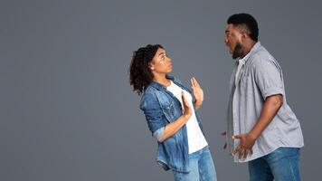 A woman standing with her hands raised appears surprised while a man facing her expresses enthusiasm or excitement. They engage in a lively conversation in a simple indoor setting. photo