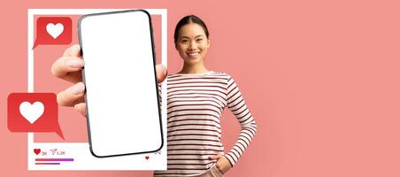 A smiling influencer holds a smartphone with a blank screen, ready to engage in social media activities. Speech bubbles with hearts indicate chatting and interaction online. photo