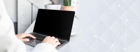 Unrecognizable businesswoman using laptop computer with white blank screen, typing on keyboard, mockup for ad, website design, copy space photo